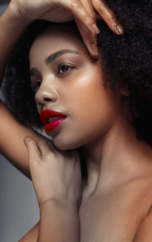 A young woman with afro hair and red lipstick.