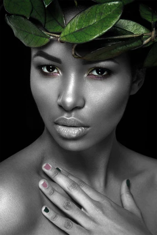 A black woman with green leaves on her head.